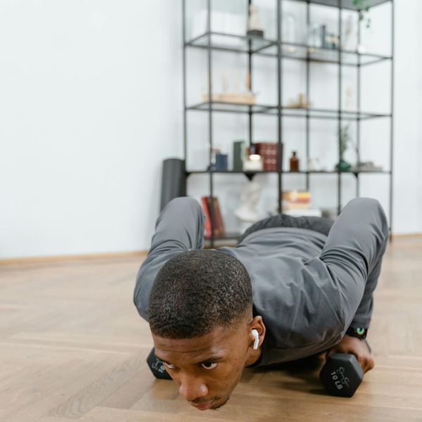 Focused man during a complex bodyweight exercise, showing concentration.